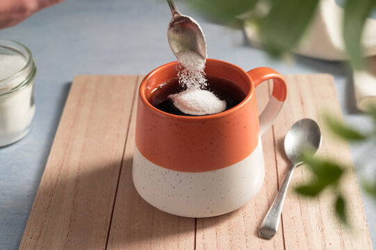 Pouring sweetener powder in cup of coffee. Sugar alternative, food and nutrition