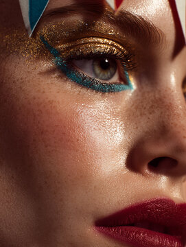 Circus inspired woman with ruby red blush and teal eyeliner against peach and gold carousel background