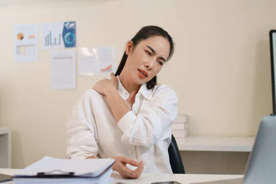 Office worker experiencing neck and back pain from prolonged computer work