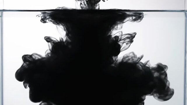 Abstract black ink cloud dissolving in clear water, mesmerizing fluid dynamics