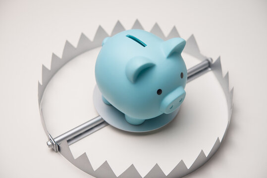 Piggy bank in trap on white background. Financial scam or fraud, savings in danger, high interest rate loan, high risk investment, financial trap, untouchable savings, money literacy and so on concept