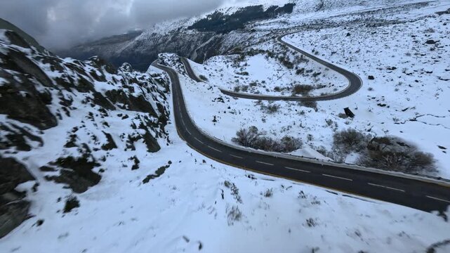 FPV drone diving down mountain road in Serra da Estrela Portugal with snow and winding route.
4K high quality dynamic cinematic FPV footage.