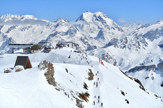 Slopes of Courchevel ski resort with skiers and snowy mountains in the background