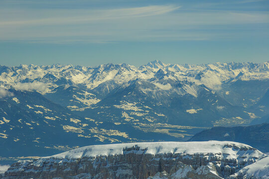 Snow covered mountain range with clear blue sky and distant peaks. landscape showcases rugged terrain and serene beauty, perfect for winter adventures and nature enthusiasts