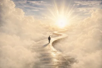 Silhouette of a man walking on winding path through the clouds, ending at a brilliant light in the distance. It symbolises heaven, afterlife, a near-death experience, path to a goal and bright future. © giedriius