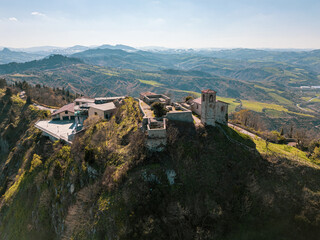 Fototapeta premium Aerial drone view of Torriana Two Towers Castle, Emilia-Romagna, Italy – dramatic hilltop fortress with medieval ruins and panoramic countryside landscape