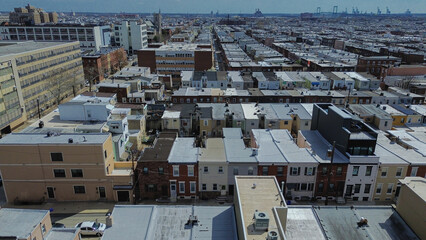 Fototapeta premium Institutional residential divide along S 9th St, Oregon Ave shows major facilities bordering compact rowhome grids, active corridors. Gray roofs, asphalt patterns, cloud filtered light, Philly, PA