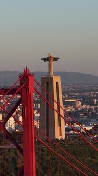 Aerial view of Christ the King in Lisbon at sunset with 25 de Abril Bridge and Tejo River.
4K high quality cinematic travel footage.