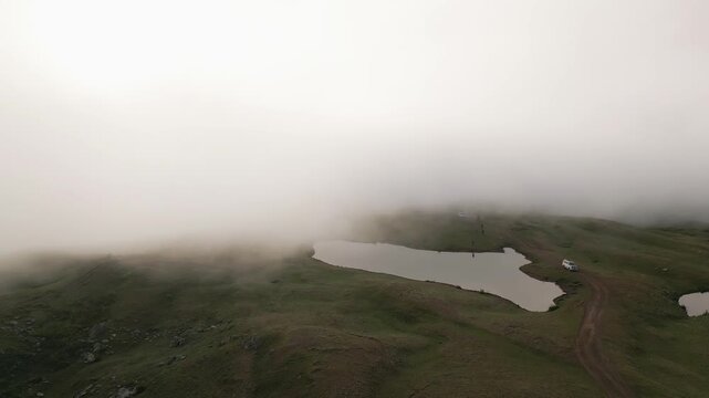 Scenic mirror reflection of a 4x4 vehicle at Koruldi Lakes, Georgia. High altitude alpine landscape in Svaneti, Caucasus mountains. Majestic nature, travel adventure, and calm water.