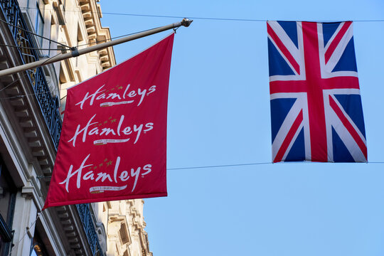 London, United Kingdom - May 20, 2023: Hamleys flag hanging next to British Union Jack, near their Regent Street site. It is well known toy retailer founded in 1760