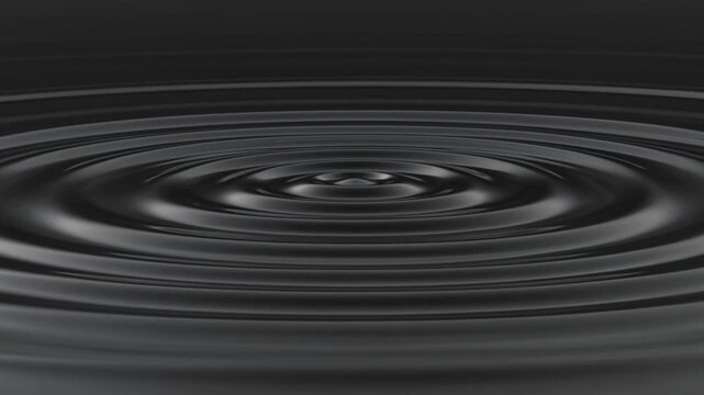 Ripples form on dark water surface with concentric circles spreading