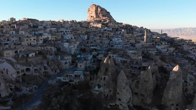 Aerial drone flight over Uchisar castle and traditional cave village in Cappadociaa Turkey at sunrise