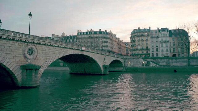 Cinematic view of Pont Louis Philippe stone bridge and Seine river in Paris during morning dusk