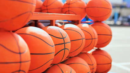 Obraz premium Many orange basketballs stacked on a storage rack, representing sports and team games