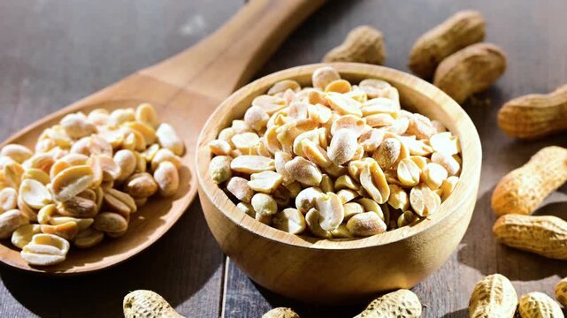 A bowl with peanuts on wooden table. Delicacies