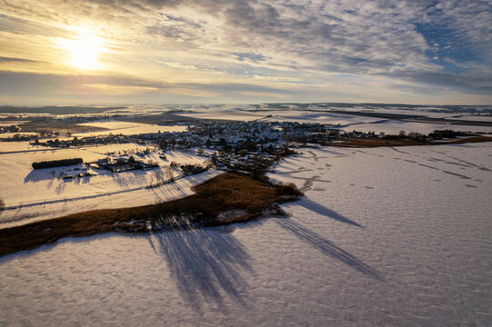 Ufer des gefrorenen S&uuml;&szlig;en See mit dem Dorf Aseleben im Hintergrund