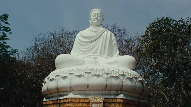 Large white Gautama Buddha statue sitting on lotus pedestal in Long Son Pagoda Nha Trang Vietnam