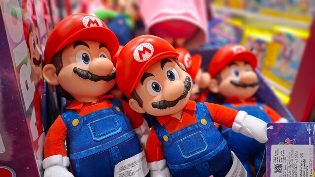 Group of Super Mario plush toys and plastic action figures with iconic red caps and blue overalls displayed in a toy store shelf on April 2, 2026 in Bangkok, Thailand.