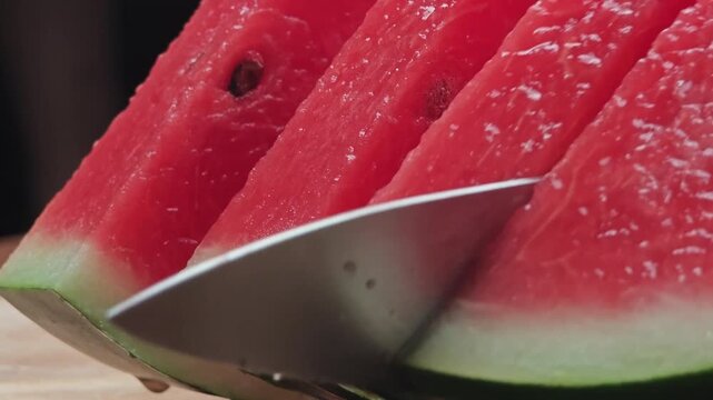 Cutting watermelon with a knife.