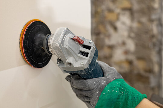 Wall grinding tool in hand during working process