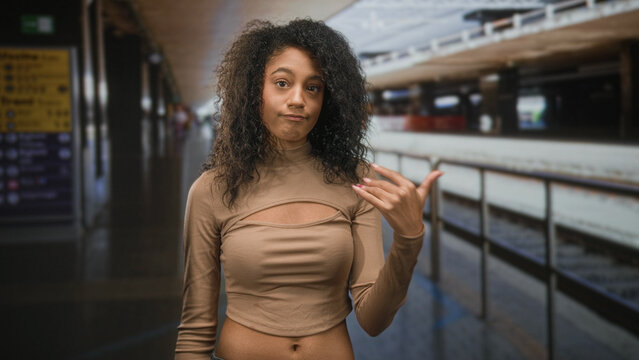 Teenage woman touching forehead then shrug gesture showing visible navel at train station platform; missed train frustration.