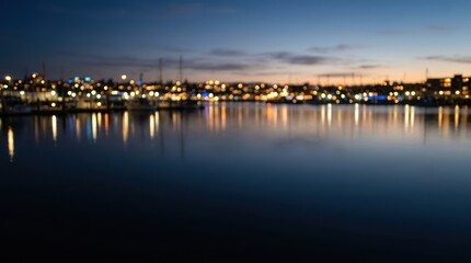 Obraz premium City lights reflected on calm water at dusk.