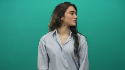 Woman wearing striped shirt and stud earring rotates head in studio; serenity contemplation focus...