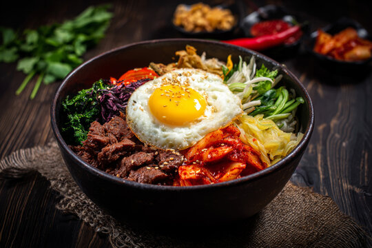 Food photography of classic Korean national dishes: bibimbap, kimbap, tteokbokki, grilled meat, and an array of banchan including kimchi and jorim. Colorful and appetizing.