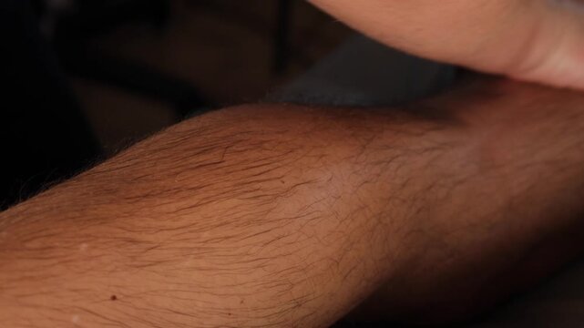 Macro close up of therapist pressing deep into male calf muscle for trigger point therapy