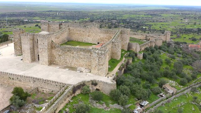 Aerial view of Trujillo Castle ruins in Caceres, Spain. Historic hilltop fortress remains open to visitors, medieval stone structures overlooking Castilla La Mancha landscape.