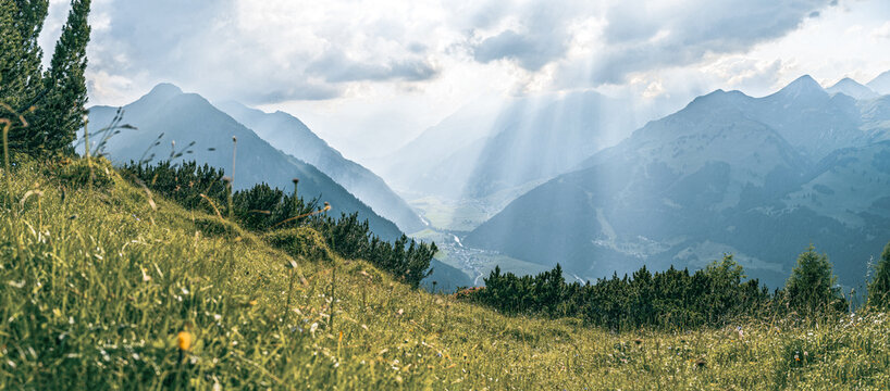 Spectacular crepuscular sun rays over the upper Lechtal valley near Holzgau and Elbigenalp. View towards Warth with Sonnenkogel and J&ouml;chlspitze peaks. Dramatic alpine light and clouds, Tyrol, Austria.