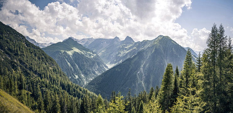Scenic view towards Etlerkopf and Mutlerkopf peaks in the Lechtal Alps. Dramatic valley with pine forest. Holzgauer Wetterspitze obscured by clouds. Pure alpine wilderness near Holzgau, Tyrol, Austria