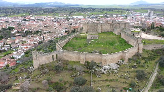 Aerial view of Trujillo Castle ruins in Caceres, Spain. Historic hilltop fortress remains open to visitors, medieval stone structures overlooking Castilla La Mancha landscape.