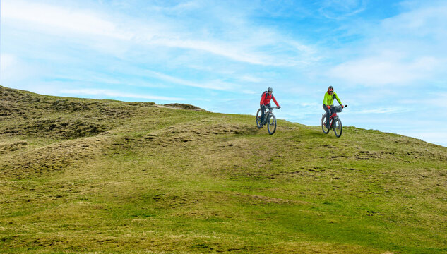 Happy senior couple enjoying an ebike mountain tour in the Allg&auml;u Alps near Oberstaufen, Bavaria, Germany. Active lifestyle, outdoor adventure, and fun in nature on a scenic alpine landscape.