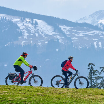 Happy senior couple enjoying an ebike mountain tour in the Allg&auml;u Alps near Oberstaufen, Bavaria, Germany. Active lifestyle, outdoor adventure, and fun in nature on a scenic alpine landscape.