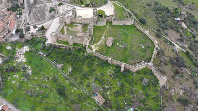 Aerial view of Trujillo Castle ruins in Caceres, Spain. Historic hilltop fortress remains open to visitors, medieval stone structures overlooking Castilla La Mancha landscape.