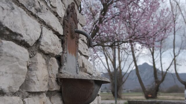 Bottom view of a fountain with running water and a stone wall, Rocchetta a Volturno, Molise, Italy