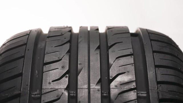 Purchase of New Car Tires. New car wheel close-up slowly spinning showing tread pattern on white background