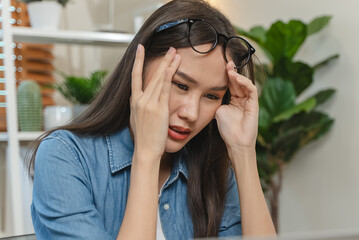 Fototapeta premium Young adult asian woman have a eyes tired after overworked looking at screen too much.