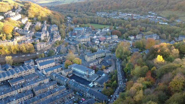 High aerial view of the town of Hebden Bridge in autumn sunlight showing streets of houses and the town centre