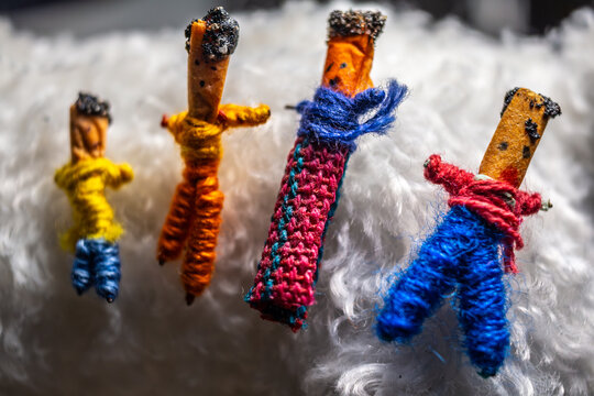 Familia de bonecos artesanais feitos com linhas coloridas em close-up sobre tecido felpudo