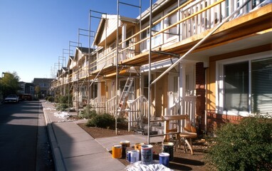 Fototapeta premium Townhouse Facade Repainting with Scaffolding and Painting Supplies Present