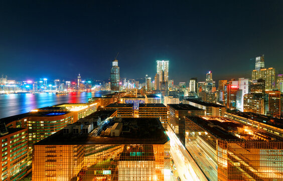 Night scenery of Hong Kong, viewed from Tsim Sha Tsui area in Kowloon Downtown, with a beautiful skyline of crowded skyscrapers by Victoria Harbour & colorful city lights dazzling in the blue twilight