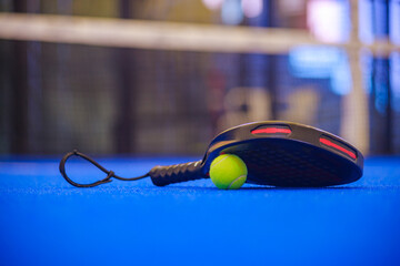 Padel tennis racket with ball. Background with copy space. Sport court and ball. Download a high quality photo with paddle for the design of a sports app or social media advertisement