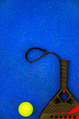 Padel tennis racket with ball. Background with copy space. Sport court and ball. Download a high quality photo with paddle for the design of a sports app or social media advertisement