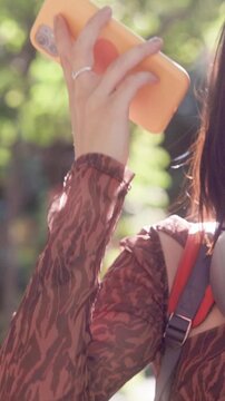 Happy young student dancing with smartphone in a public park