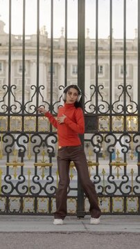 Happy energetic woman dancing in front of the royal palace of Madrid