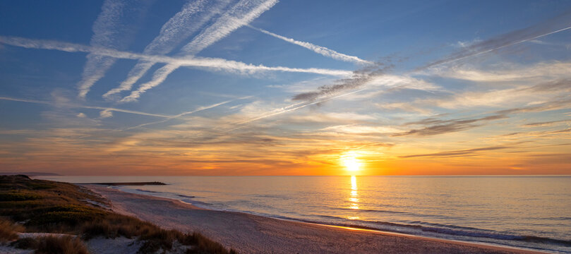 Golden sunset over the coastal dunes and pristine shoreline of Mira Villa Beach in Portugal PRT
