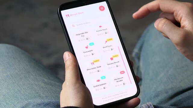 Man browsing a cooking app for dinner ideas. High-quality footage of a smartphone screen showing diverse recipes like Carbonara and Curry. Ideal for meal planning, nutrition blogs, and modern kitchen