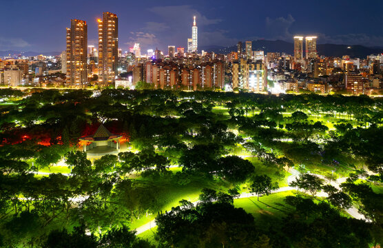 Night skyline of Taipei Downtown, viewed from above Daan Forest Park, with residential buildings & condos standing next to the city's lungs and 101 Tower among high-rise skyscrapers in Xinyi District